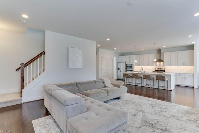 living area featuring dark wood-style floors, recessed lighting, and stairway