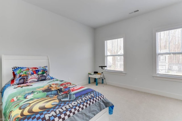 bedroom with carpet floors, multiple windows, visible vents, and baseboards