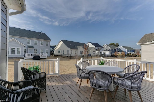 wooden deck featuring outdoor dining area and a residential view