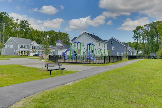 community play area featuring a yard, a residential view, and fence