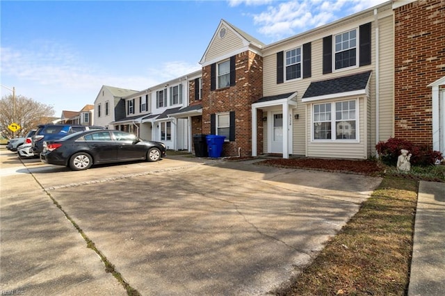 townhome / multi-family property with a residential view and brick siding