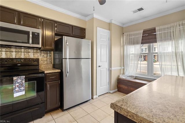 kitchen with crown molding, light tile patterned floors, tasteful backsplash, visible vents, and appliances with stainless steel finishes