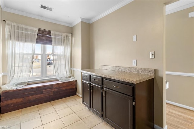 kitchen with light countertops, visible vents, crown molding, and light tile patterned flooring