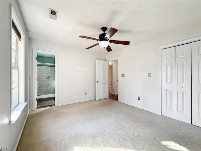 unfurnished bedroom featuring a closet, light carpet, visible vents, and baseboards