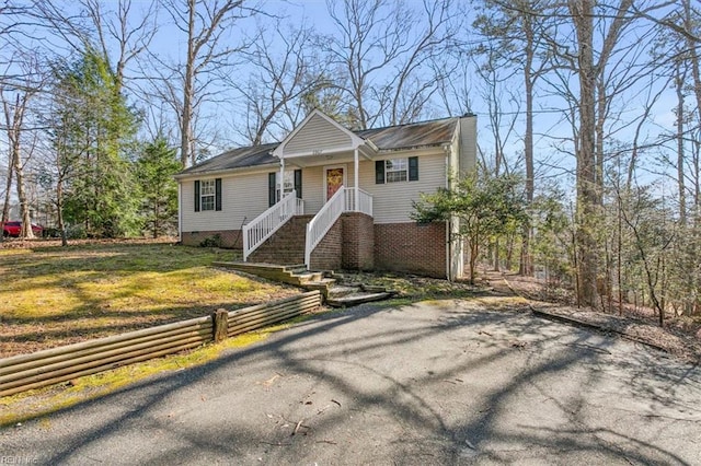 view of front of house featuring crawl space, driveway, and a front yard