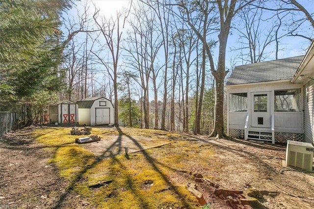 view of yard featuring entry steps, a storage shed, fence, cooling unit, and an outdoor structure