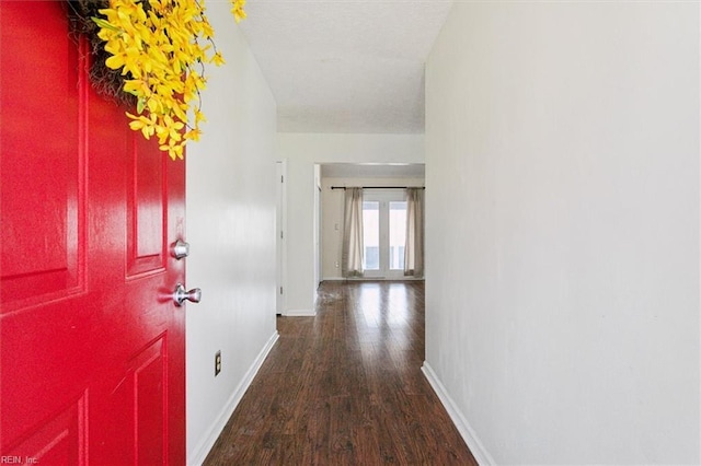 hallway with wood finished floors and baseboards