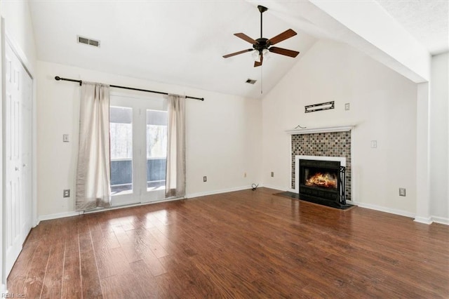 unfurnished living room featuring a tile fireplace, visible vents, ceiling fan, and wood finished floors