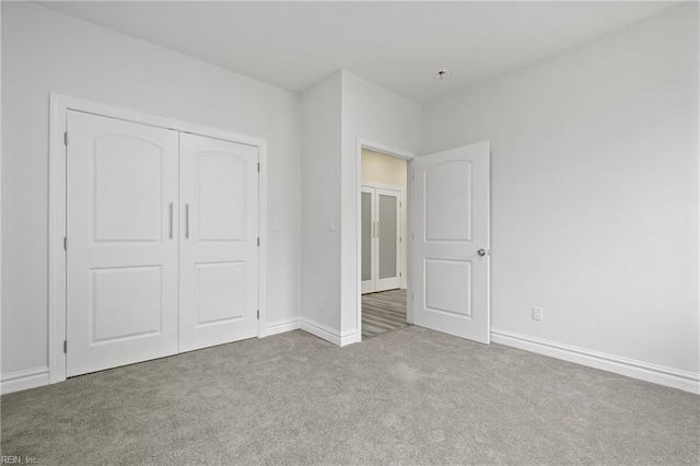 unfurnished bedroom featuring a closet, carpet, and baseboards