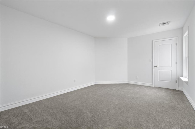 unfurnished room featuring carpet floors, visible vents, and baseboards