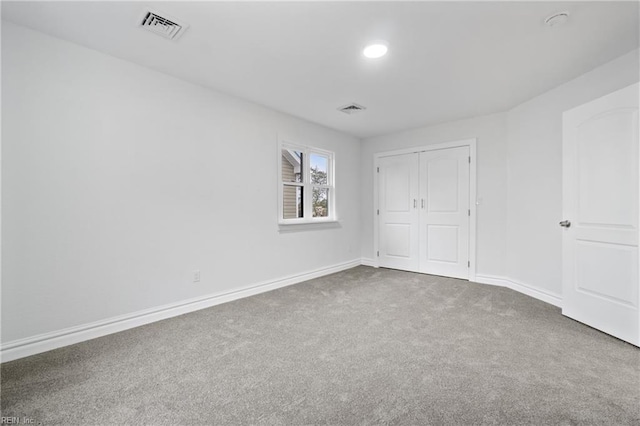 unfurnished bedroom with carpet, a closet, visible vents, and baseboards