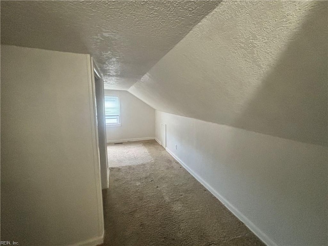 bonus room with a textured ceiling, carpet, lofted ceiling, and baseboards