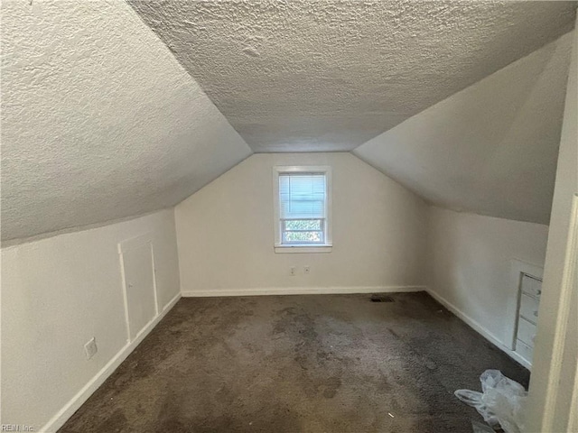 bonus room featuring vaulted ceiling, a textured ceiling, carpet, and baseboards