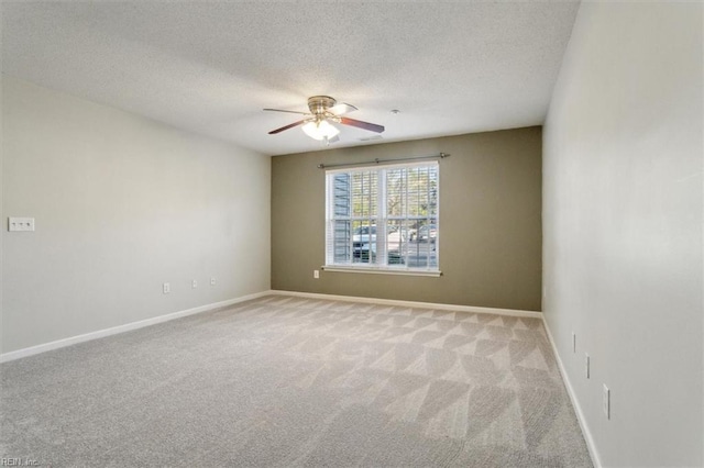 unfurnished room with carpet floors, ceiling fan, a textured ceiling, and baseboards