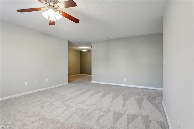 carpeted empty room with ceiling fan and baseboards