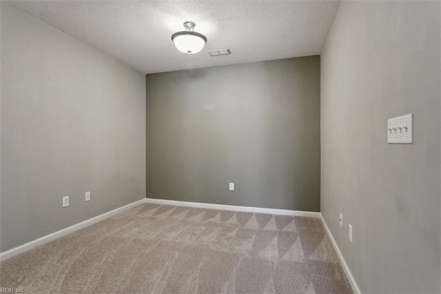 unfurnished room featuring visible vents, carpet flooring, a textured ceiling, and baseboards