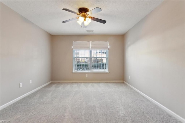 empty room featuring a textured ceiling, visible vents, and baseboards