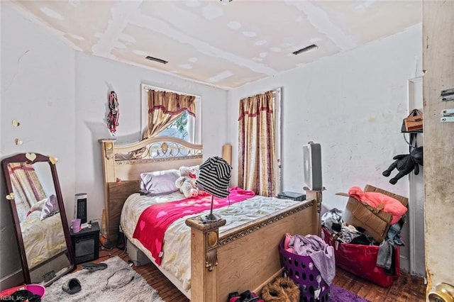 bedroom with visible vents and wood finished floors