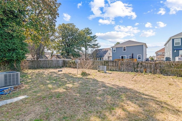 view of yard with cooling unit, a fenced backyard, and a residential view