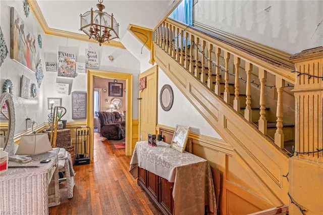 stairs with an inviting chandelier, wood-type flooring, and crown molding