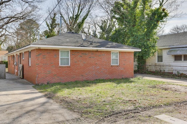 view of side of property featuring a yard and brick siding