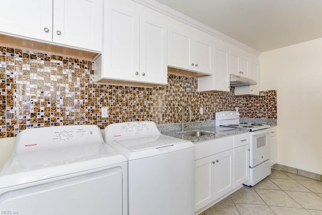 laundry area featuring light tile patterned floors, independent washer and dryer, a sink, and baseboards