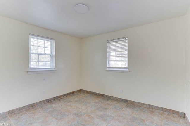 spare room with baseboards and a wealth of natural light