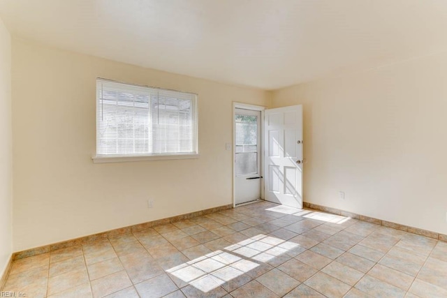 unfurnished room featuring light tile patterned floors and baseboards