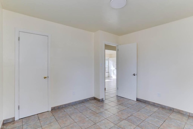 unfurnished room with baseboards and light tile patterned floors