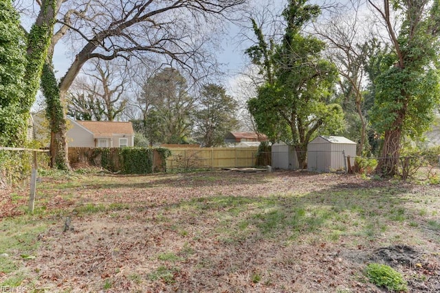 view of yard featuring an outbuilding, a fenced backyard, and a shed