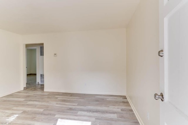 spare room featuring baseboards, visible vents, and light wood finished floors