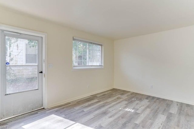 unfurnished room with baseboards and wood finished floors