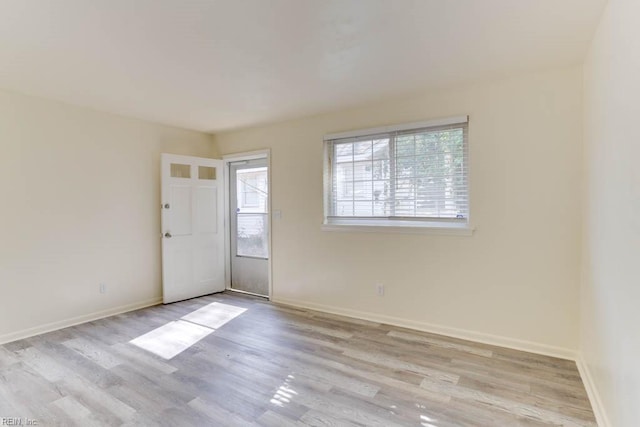 unfurnished room with baseboards and wood finished floors