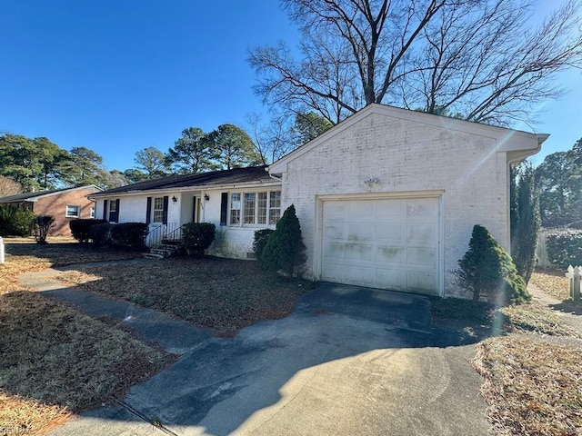 ranch-style home featuring brick siding, driveway, and an attached garage