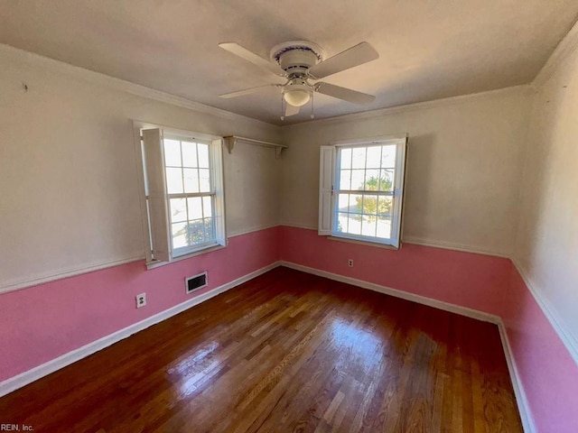 unfurnished room with crown molding, visible vents, ceiling fan, wood finished floors, and baseboards