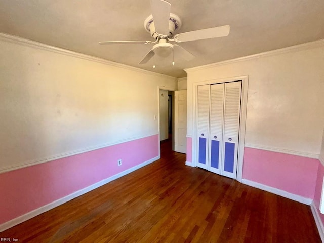 unfurnished bedroom featuring baseboards, a closet, wood finished floors, and crown molding