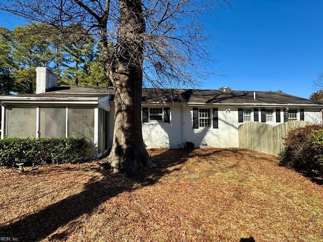 exterior space with a sunroom, crawl space, fence, and a chimney