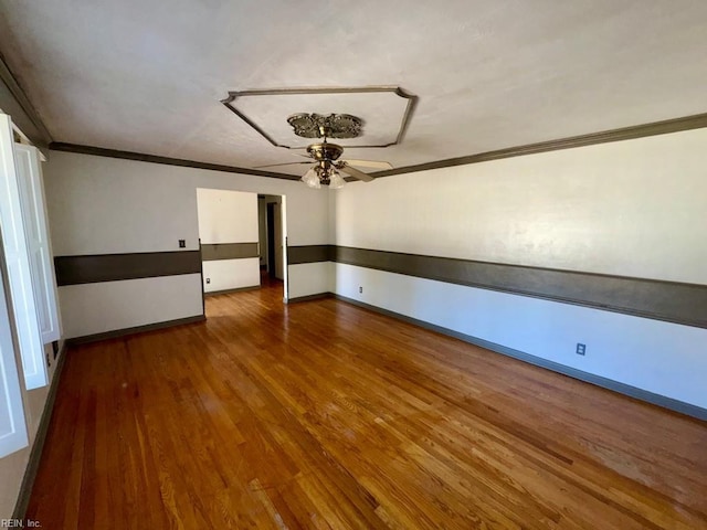 unfurnished room with a ceiling fan, crown molding, baseboards, and wood finished floors