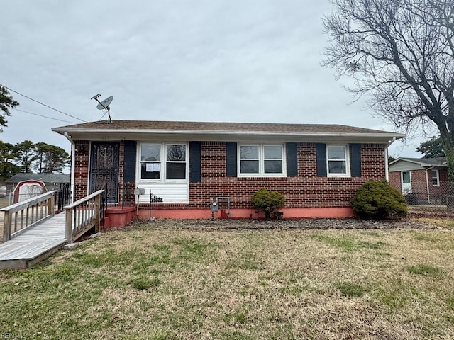 ranch-style house featuring fence, a front lawn, and brick siding