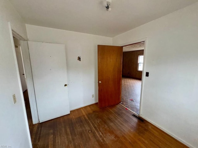 unfurnished bedroom featuring visible vents and hardwood / wood-style floors