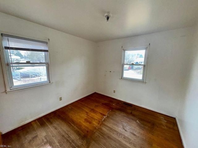 unfurnished room featuring baseboards and wood finished floors