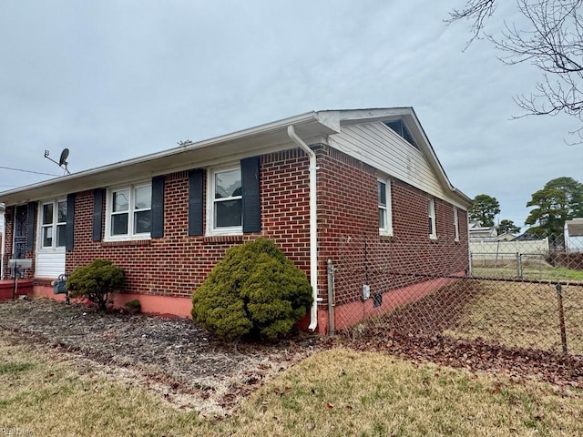 view of property exterior featuring fence and brick siding