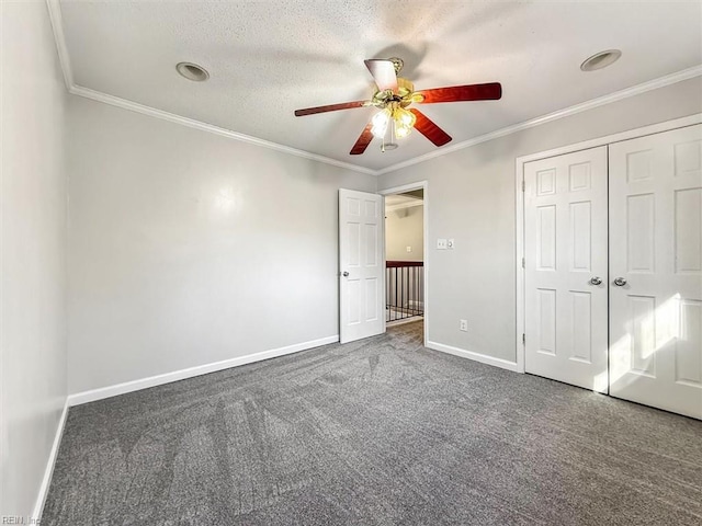 unfurnished bedroom with carpet floors, ornamental molding, a closet, and baseboards