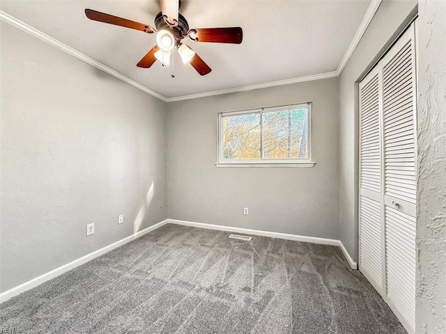 unfurnished bedroom with baseboards, ceiling fan, ornamental molding, carpet, and a closet