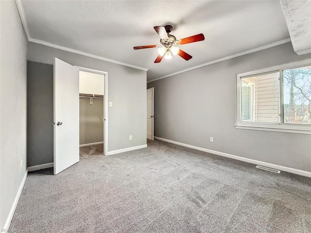 unfurnished bedroom with crown molding, carpet flooring, visible vents, and baseboards