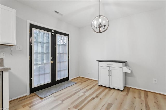 doorway to outside featuring light wood-type flooring, baseboards, visible vents, and french doors