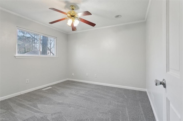 spare room with ornamental molding, carpet flooring, baseboards, and a ceiling fan