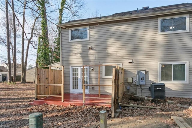 rear view of property featuring central air condition unit, a wooden deck, and french doors