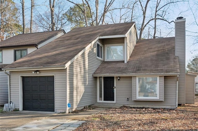 view of front facade featuring a shingled roof, concrete driveway, a chimney, and an attached garage