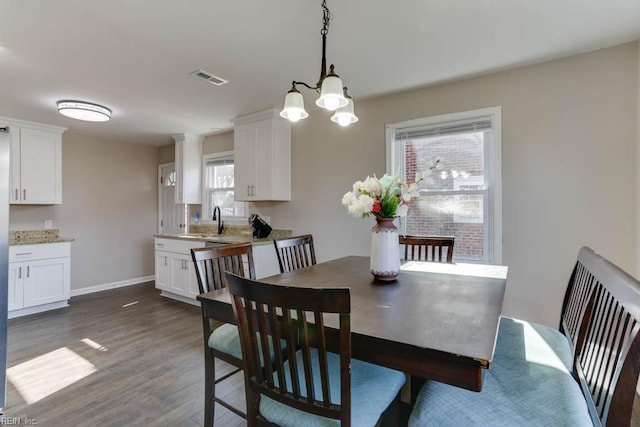 dining space with dark wood-style flooring, visible vents, and baseboards